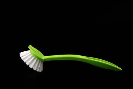 Green dishwashing brush isolated on black backgroundの写真素材