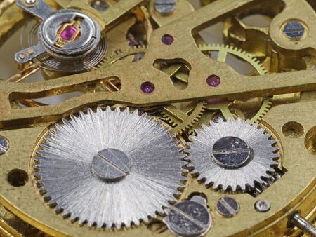 close up backside of clockwork mechanism of a golden pocket watch.