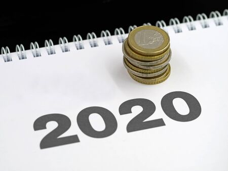 stack of euro coins on calendar 2020, concept of expenditure or taxes payment, costs change in the...