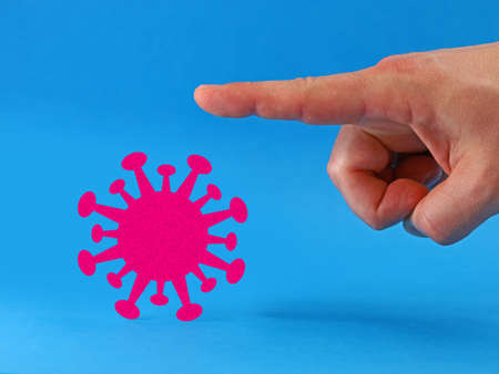 finger shows corona virus the way isolated on blue background, good bye pandemic concept image