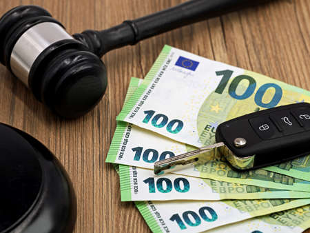 jugde gavel or auction hammer with euro money banknotes and car keys on wooden tableの写真素材