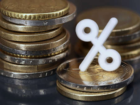 Stacks of euro coins with white percent sign, concept of investing money or getting a discount to...