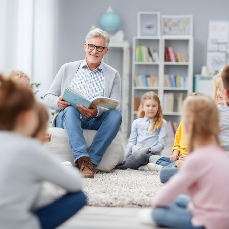 senior man reading book to his kids at school or nursery schoolの素材
