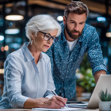 Portrait of mature businesswoman and her colleague working together in officeの素材