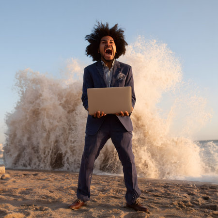 Portrait of a happy afro-american man with a laptop on the beachの素材