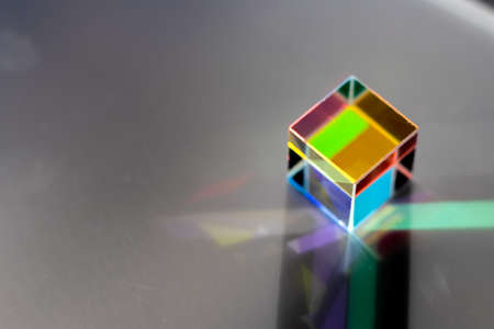 Colored square crystal with a rainbow on a substrate in close-up