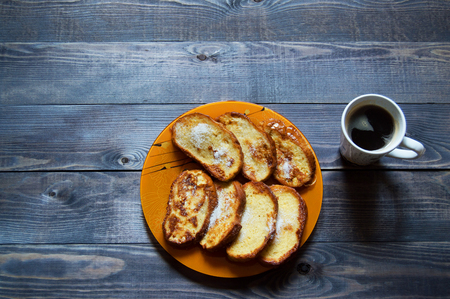 Breakfast bread and black coffe on wooden tableの写真素材