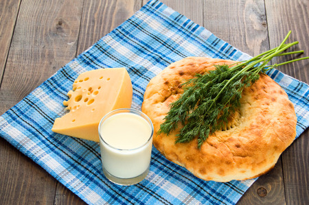 Bread cheese, greenery dill and milk on wooden tableの写真素材