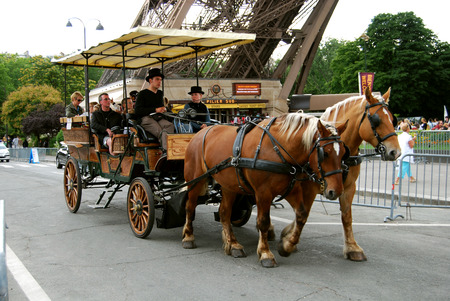 horse-drawn carriage rolls of people near the Eiffel tower photo of 2012 Parisのeditorial素材
