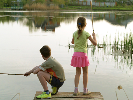 children,boy and girl fishing stand on the bridge and fishの写真素材