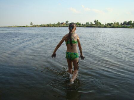 child puts river mud on his body on the river Bankの写真素材