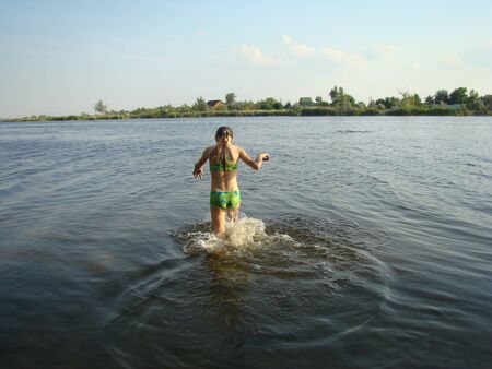 child puts river mud on his body on the river Bankの写真素材