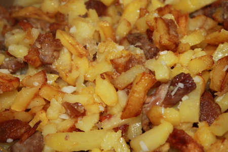 fry the potatoes in a frying pan, turning them over so as not to burnの写真素材