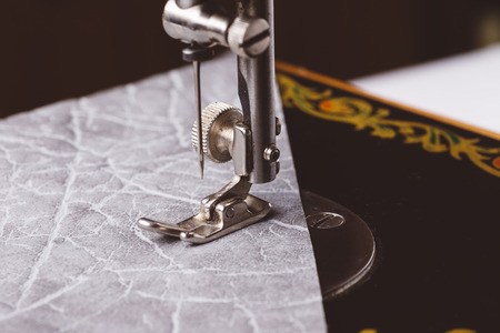 Sewing machine parts close up shot in process of work. Retro style stylized imageの写真素材