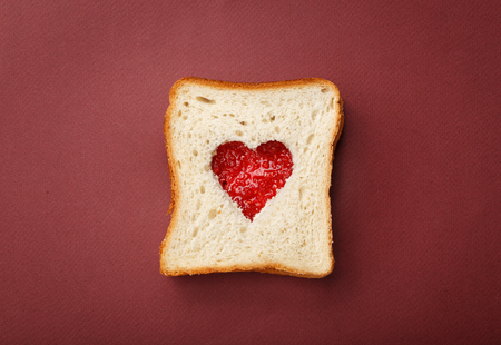 Two pieces of toast bread stacked in a sandwich. Inside of it cut heart filled with raspberry jam. Valentine's Day.
の写真素材