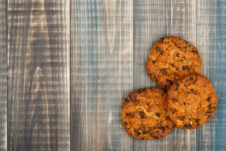 Oatmeal cookies with chocolate chips lie on a wooden background. There is a place for text on the left.
の写真素材