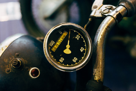 Old speedometer on the motorcycle handlebar. Retro picture. Selective focus.