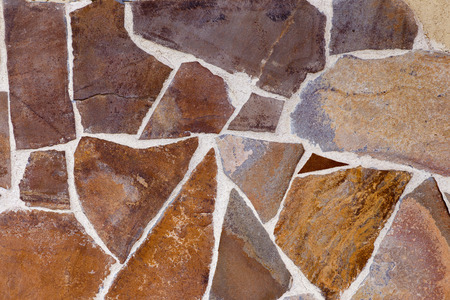 Mosaic collected from decorative stones of various shapes. Stone background.