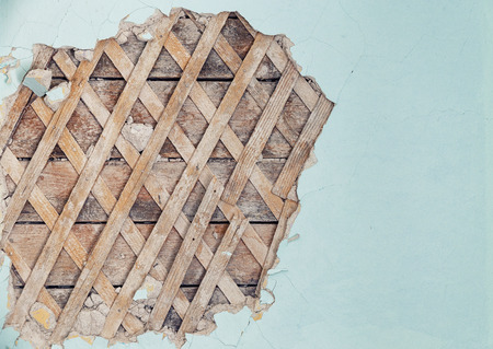 Part of the wall of the old house with partially peeled plaster where the wooden crate can be seenの写真素材