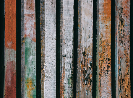 Bright wooden background from colored vertical boards with peeling paintの写真素材
