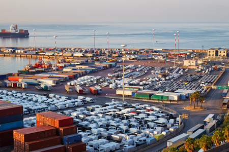 Port terminal with containers, new cars and wagons in the early morningの写真素材