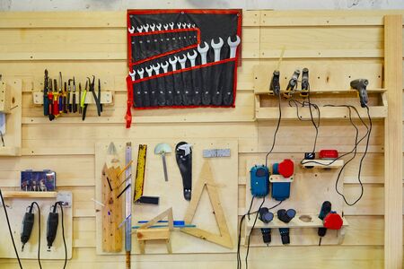 Tools hanging on the wall in a carpentry workshop. Wrenches, screwdrivers, pliers, coals, etc. Workshop sceneの写真素材