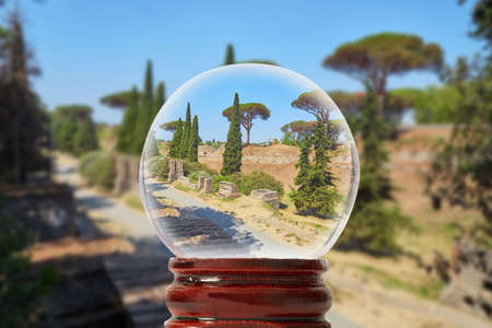 The road between ruins in Pompeii on a summer sunny day through a glass transparent ballの写真素材