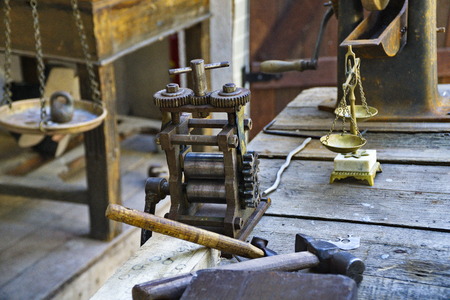 antique tools and mechanisms laid out on a wooden tableの写真素材