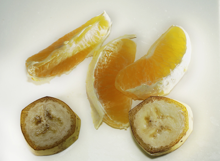 banana slices and orange slices on white backgroundの写真素材