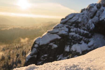 Granite rock in the winter forest at sunset.の写真素材