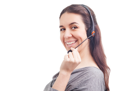Portrait of happy smiling cheerful young support phone operator in headset showing copyspace area or something, isolated on white backgroundの写真素材