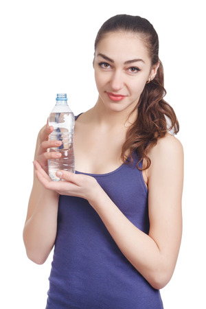 Beautiful athletic girl looks hold a bottleの写真素材