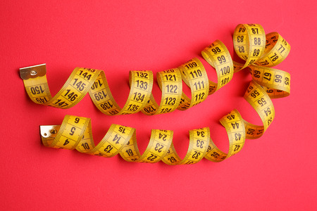 yellow measuring tape on red background