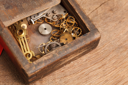 Gears and parts of the clock in the old wooden box