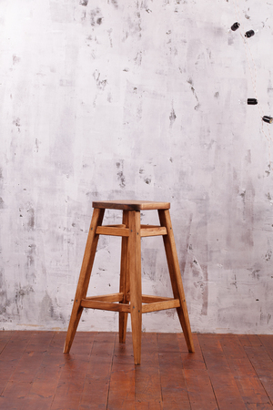 Wooden chair on the background of a concrete wallの写真素材