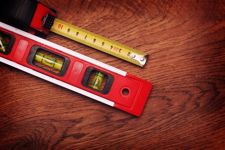 tape measure and building level on wooden background