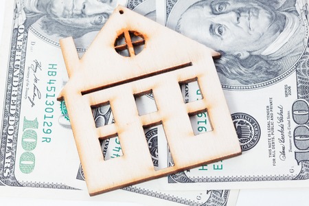 Model of wooden house with dollar bills. House building, loan, real estate, cost of housing or buying a new home concept.の写真素材