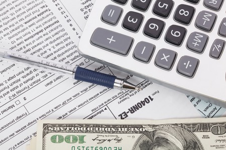 Money and calculator on tax form background