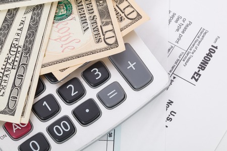 Money and calculator on tax form backgroundの写真素材