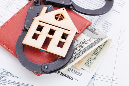 Money and wooden house on tax form backgroundの写真素材