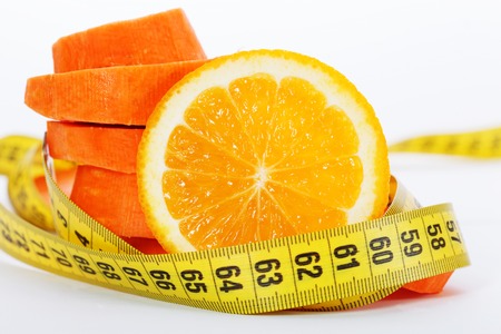 Slices of orange with slices of carrot and measuring tapeの写真素材