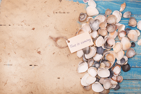 Shells and sand with sign - Time is coming. Vocation and travel backgroundの写真素材