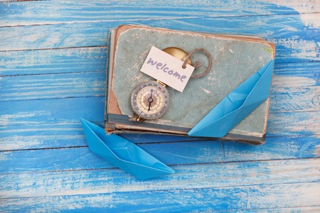 Sign Welcome and Compass on old book - Vintage style