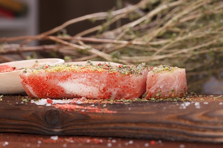 Raw juicy meat steak on dark wooden backgroundの写真素材