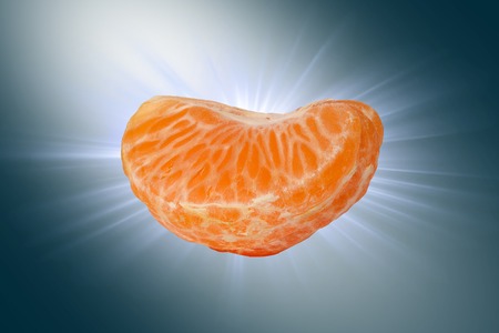 Slice of Juicy tangerine on a blue background.の写真素材