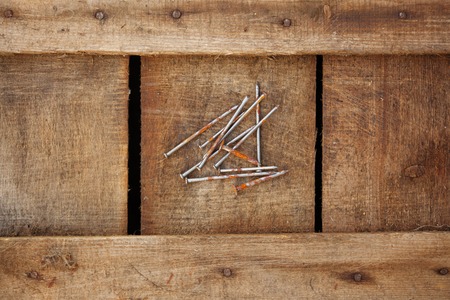 Rusty nails on dark wood texture background surface with old natural patternの写真素材