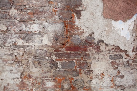 old medieval plaster and brick wall in shadowの写真素材