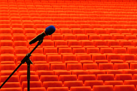 Microphone in the auditorium or conference hall with red seats.