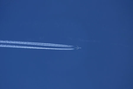 Airplane trail in the blue sky, closeup of photo.の写真素材
