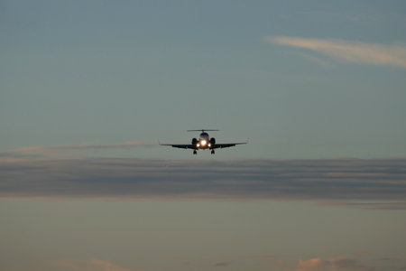 Airplane in the blue sky at sunset with clouds in the background